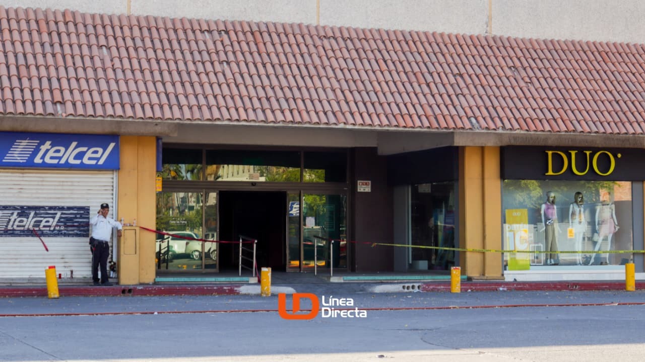 Fachada de plaza cpomercial incendiada con tiendas y cintas amarillas de precaución