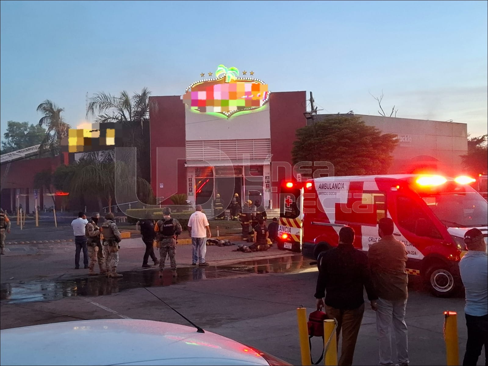 Casino con humo negro y sirenas rojas de bomberos