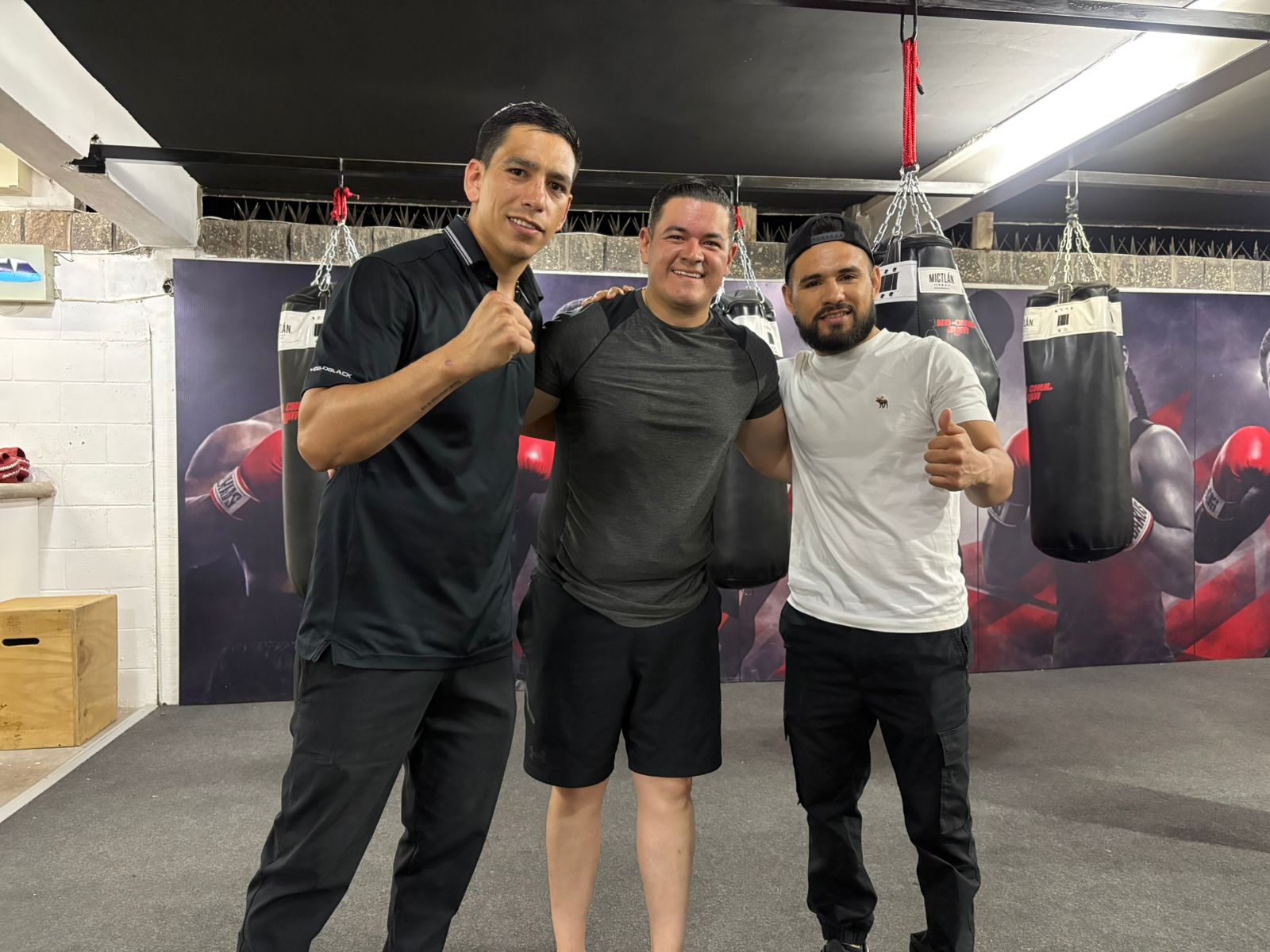 Boxeadores dentro de un gimnasio posando para la foto