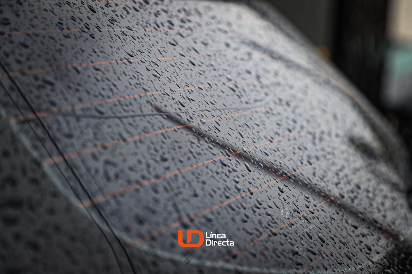 vidrio de la ventana trasera de un carro con gotas de agua luego de la lluvia