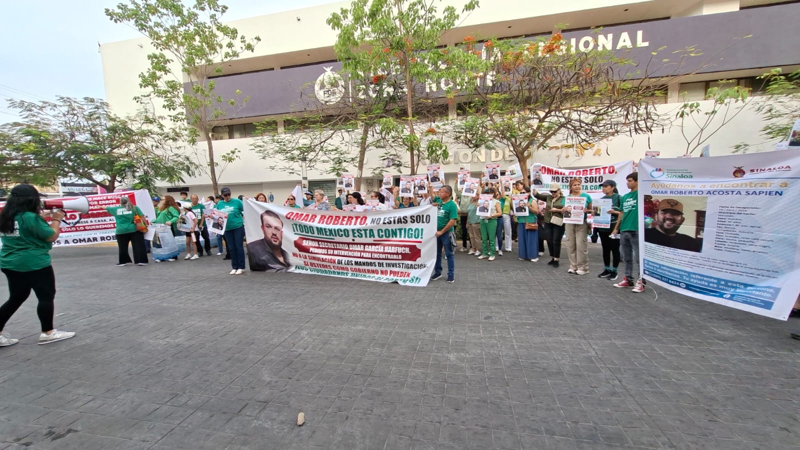 Personas con lonas y playeras verdes frente a la vicefiscalía regional zona norte