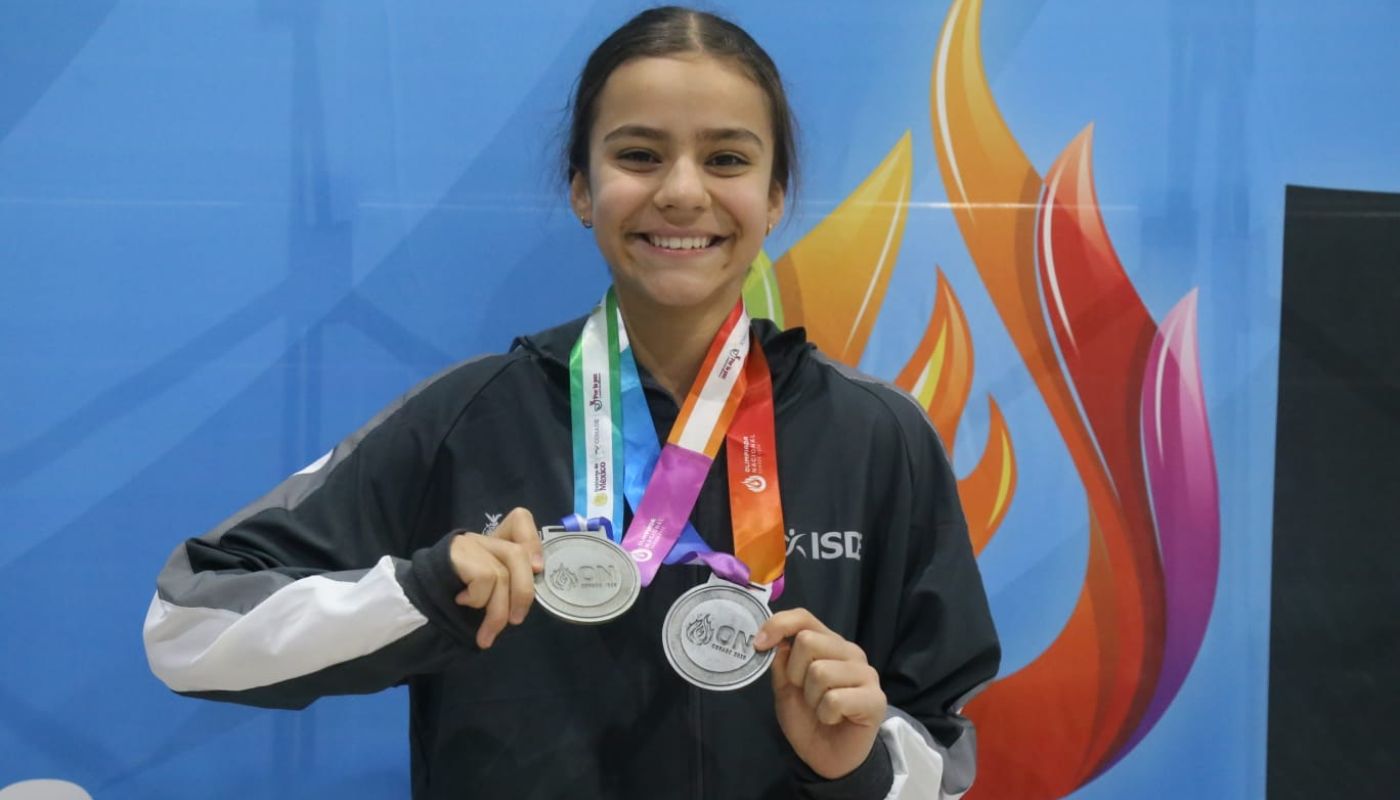 Nadadora María Luna sosteniendo sus medallas y posando para la foto
