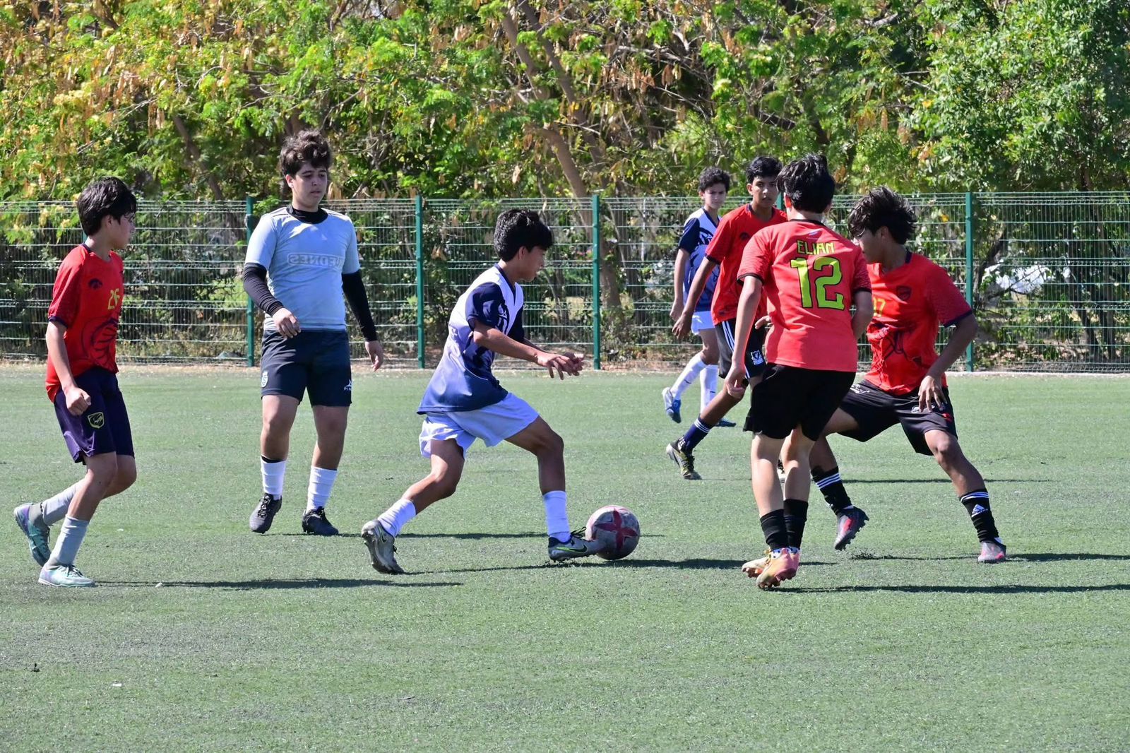 Jóvenes disputando un partido de futbol.