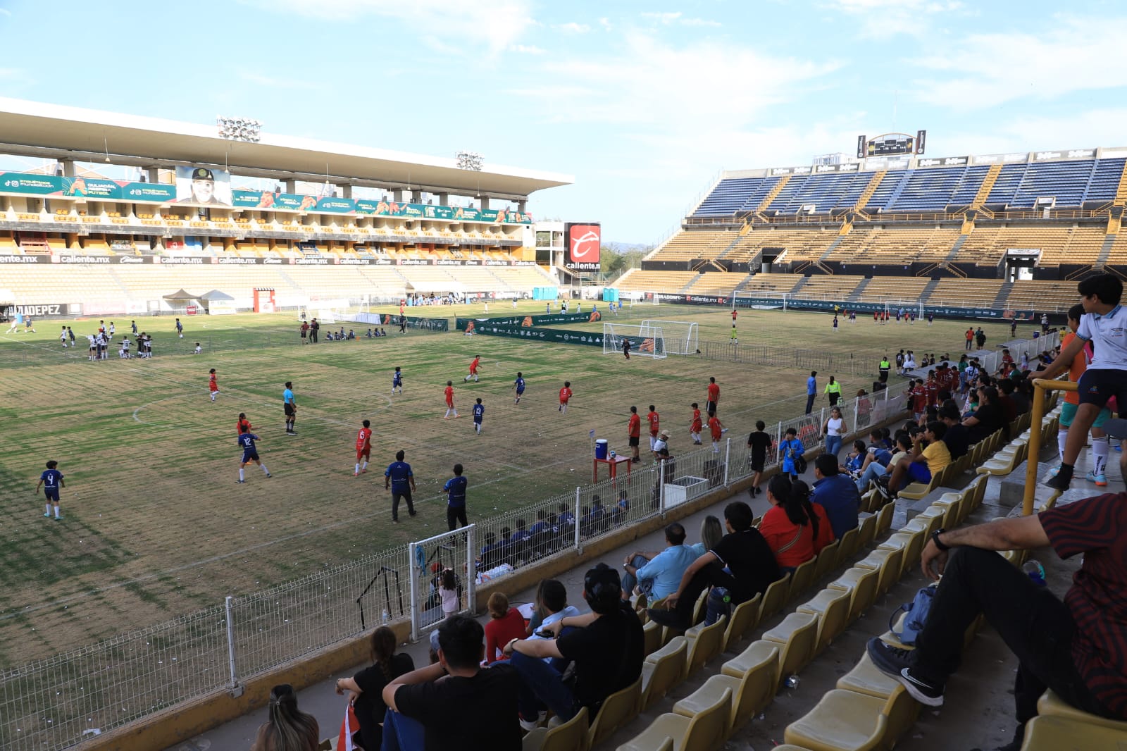 Estadio de los Dorados con personas en las gradas y en la cancha
