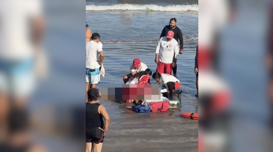 Elementos de la cruz roja realizando reanimación a una persona en mar