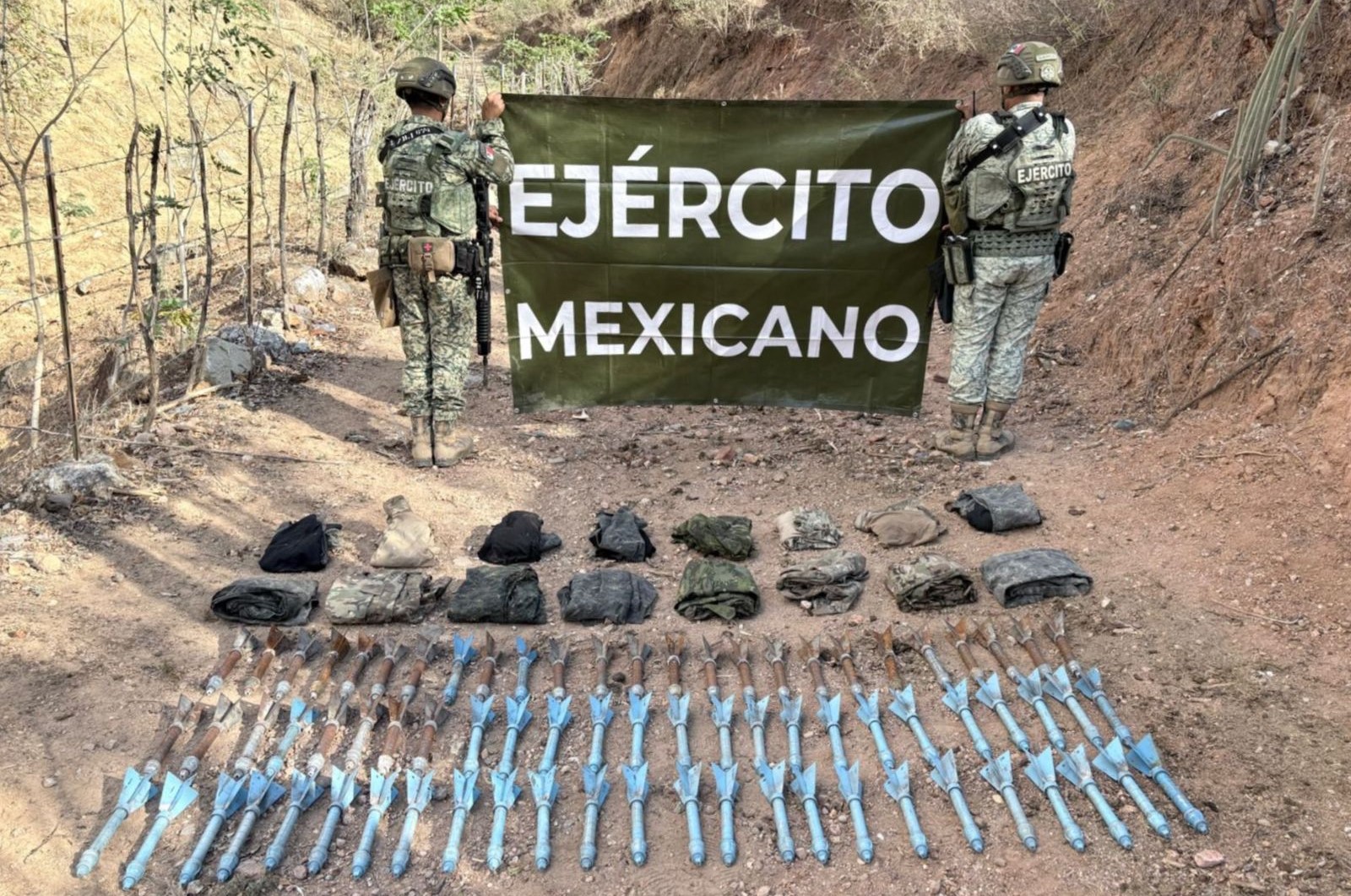Elementos de ejército mexicano de espaldas con pancarta
