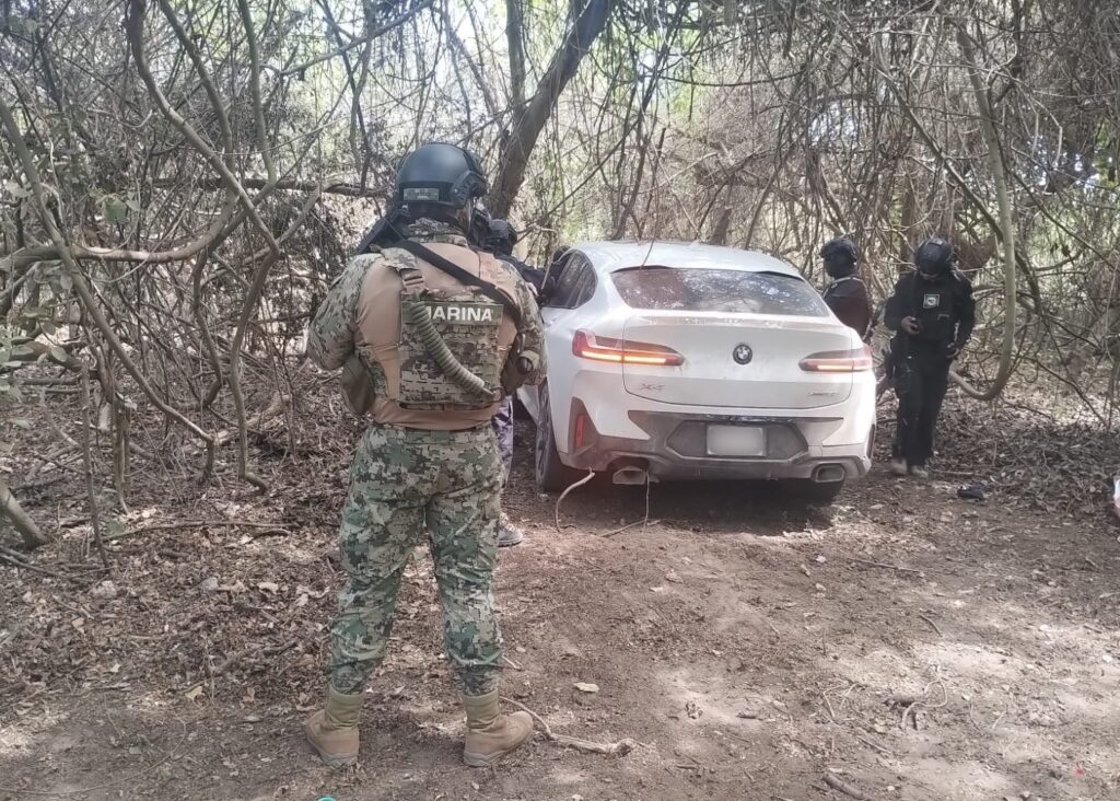 Camioneta blanca en la sierra junto a elementos de seguridad