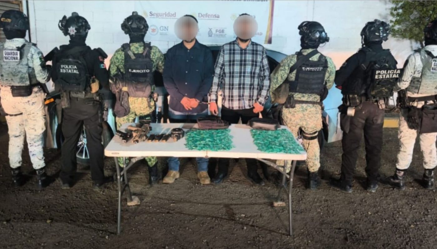 personas detenidas al medio y en las orillas elementos de seguridad y en una mesa artefactos confiscados