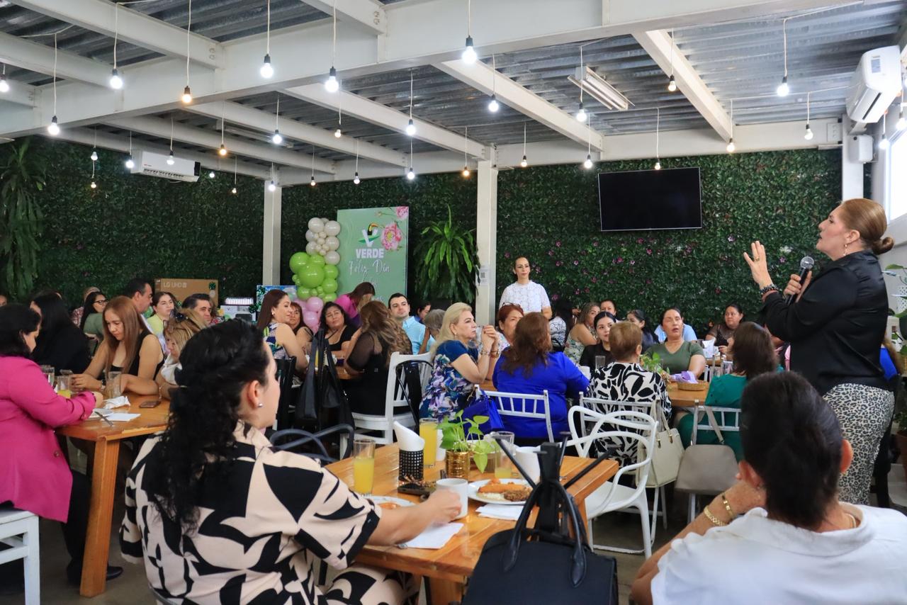 Mujeres sentadas en un restaurante con una mampara del Partido verde con globos