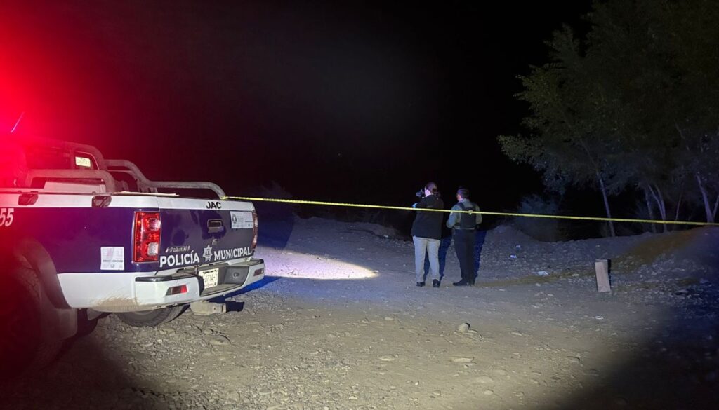 Unidad policiaca junto a una cinta amarilla de precaución y elementos en la zona