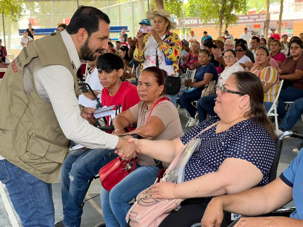 Ángel Ulises Piña García saludando a personas en silla de ruedas