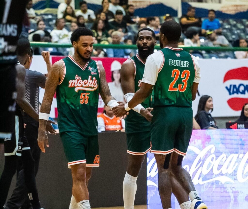 Jugadores de basquetbol en cancha con uniforme verde