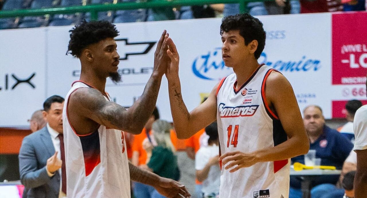 Dos jugadores de Pioneros de Los Mochis chocando las manos