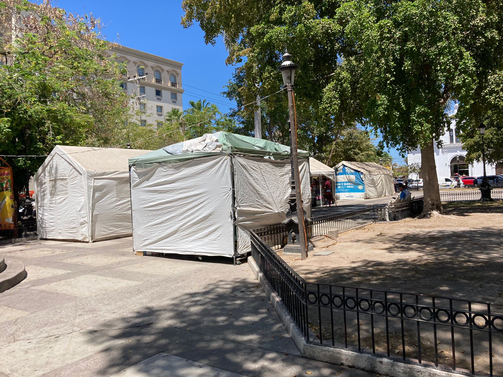 Carpas blancas en la plazuela junto a bancas