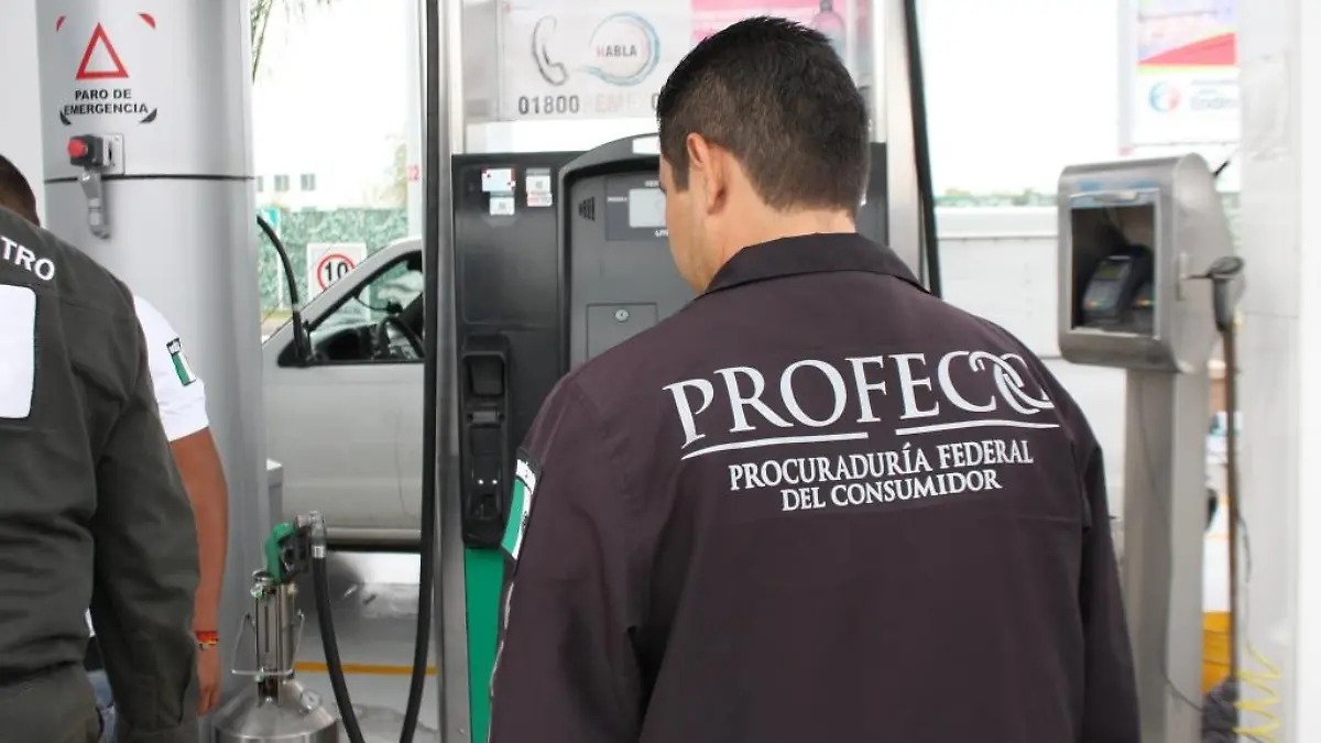 Persona de espaldas con uniforme negro de Profeco en gasolinera