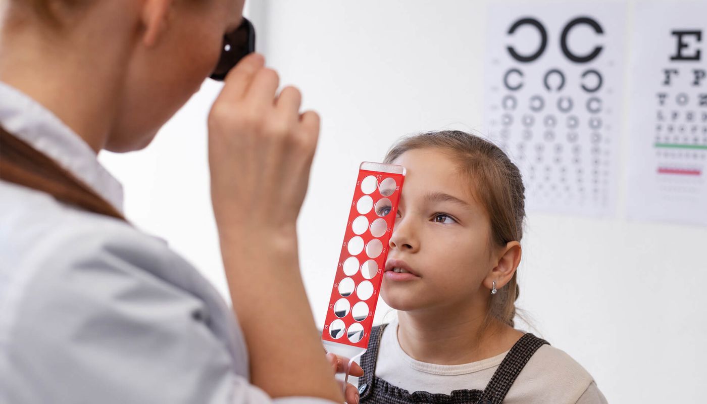 Médico realizando estudio de la vista a una menor de edad