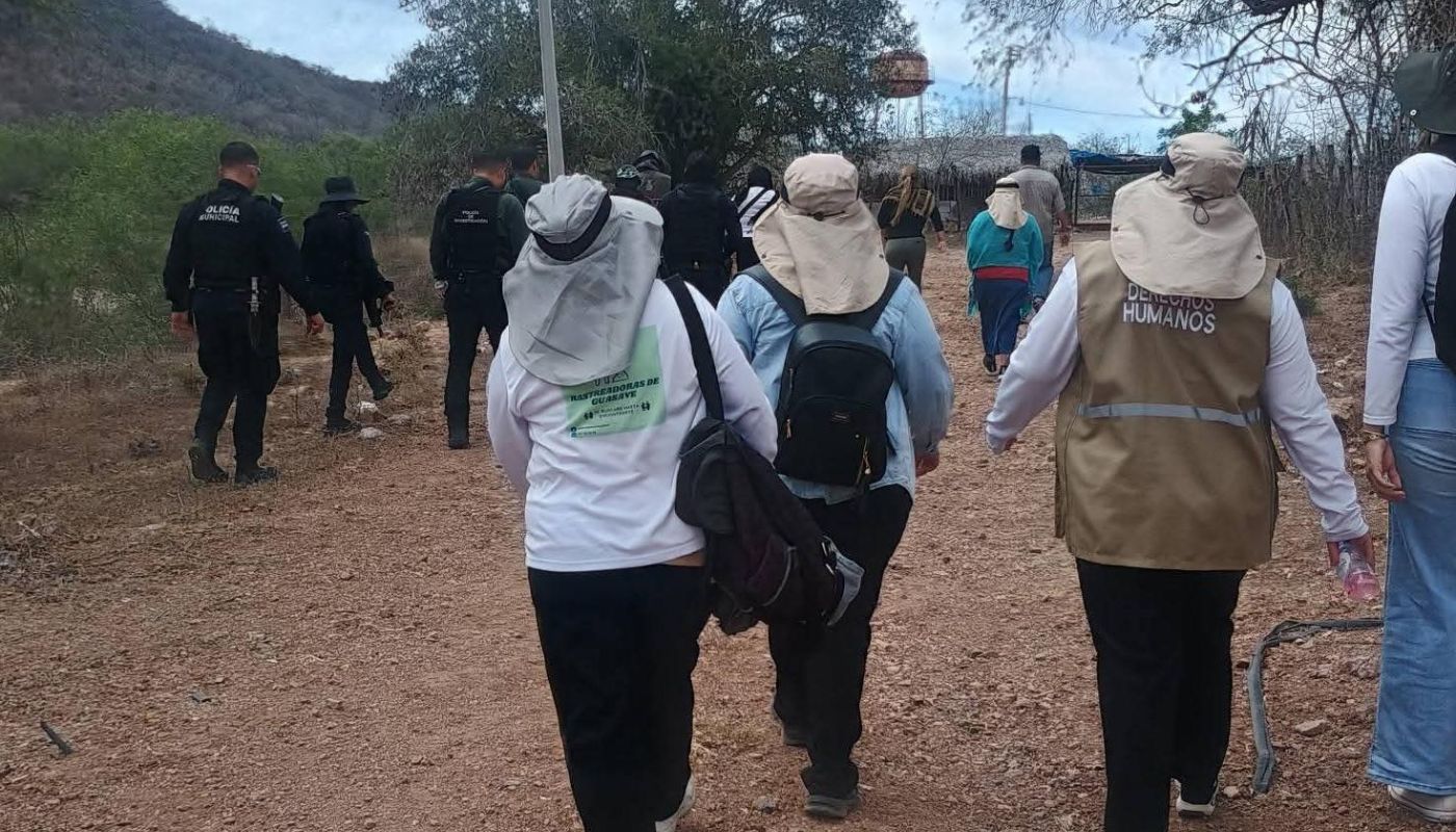 Elementos policiacos y de un colectivo de mujeres rastreadoras en un camino de terracería