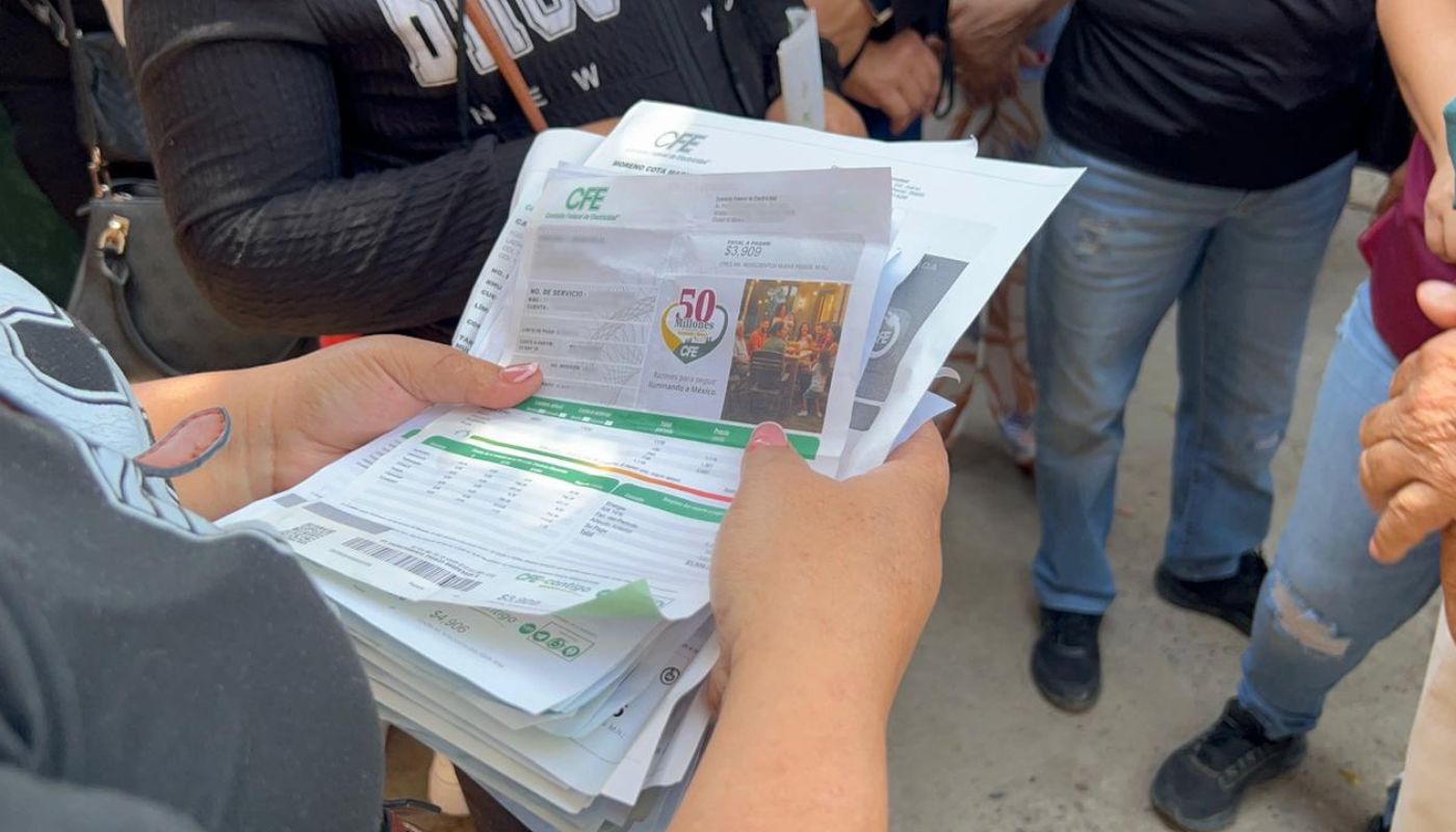 PErsona sosteniendo un recibo de luz de CFE