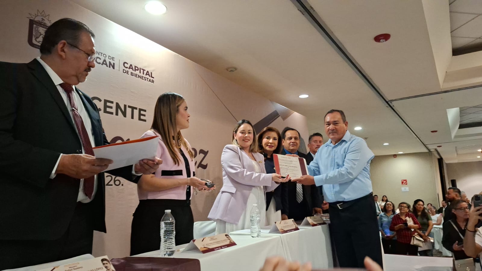 Alcaldesa de Culiacán junto a maestro entregando un diploma
