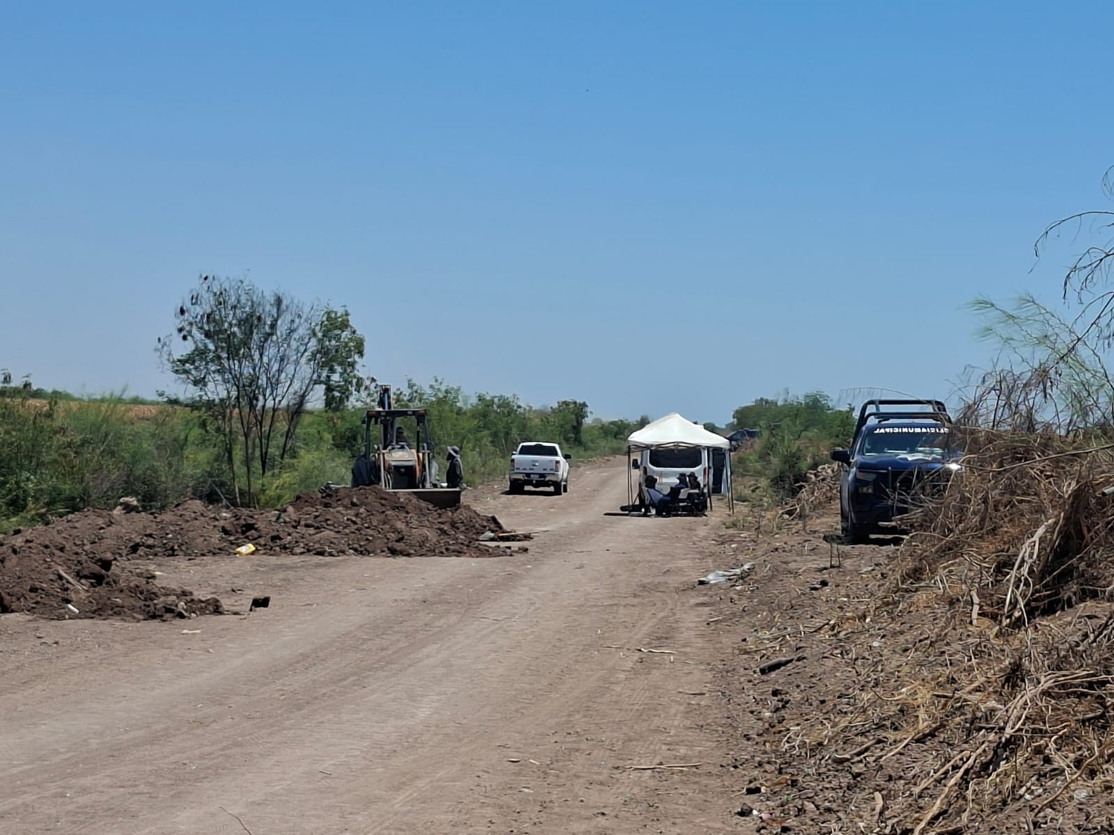 Bultos de tierra en terreno junto a unidad de la policía