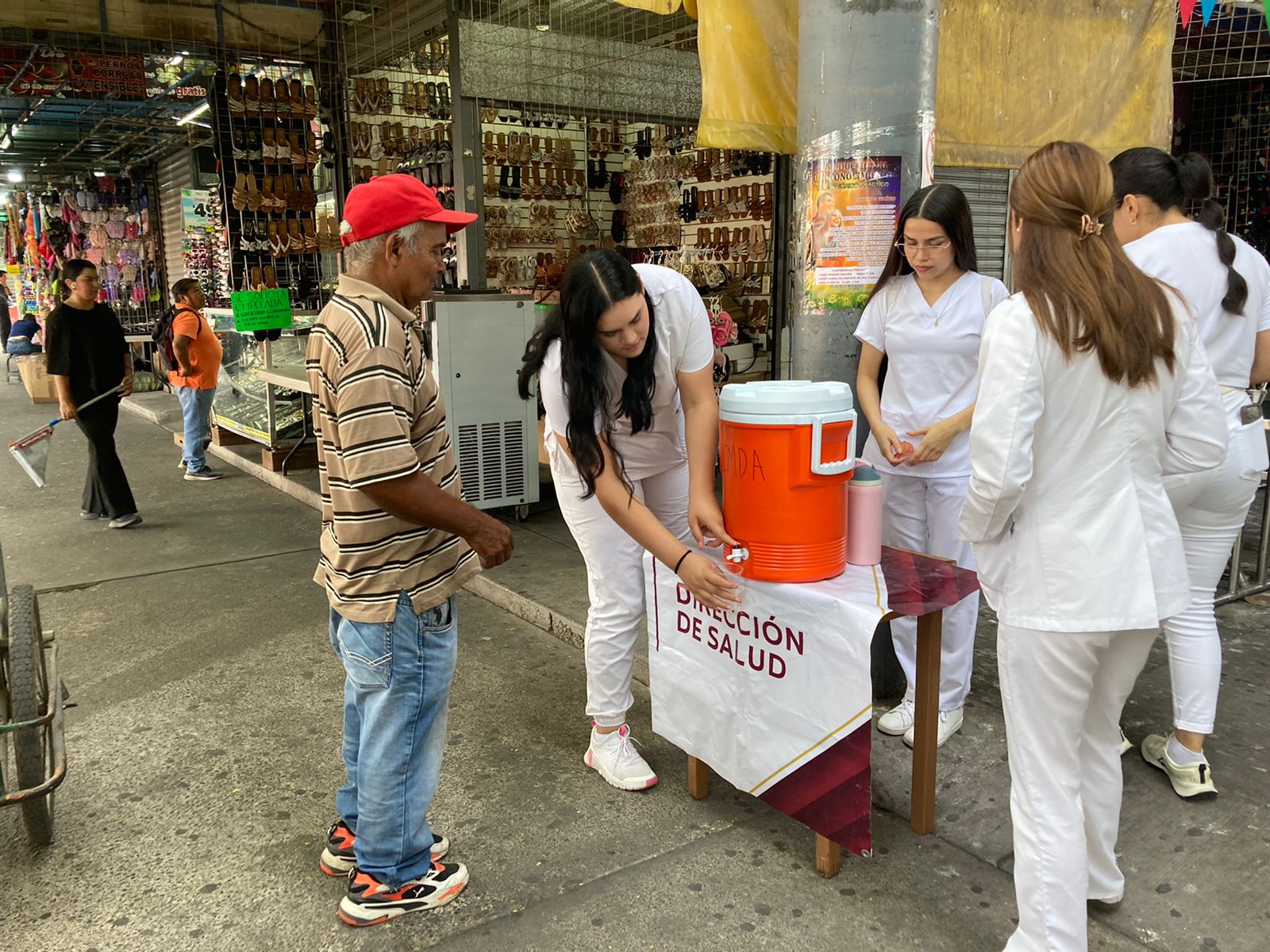 Mujeres vestidas con uniforme blanco y sirviendo agua a señor