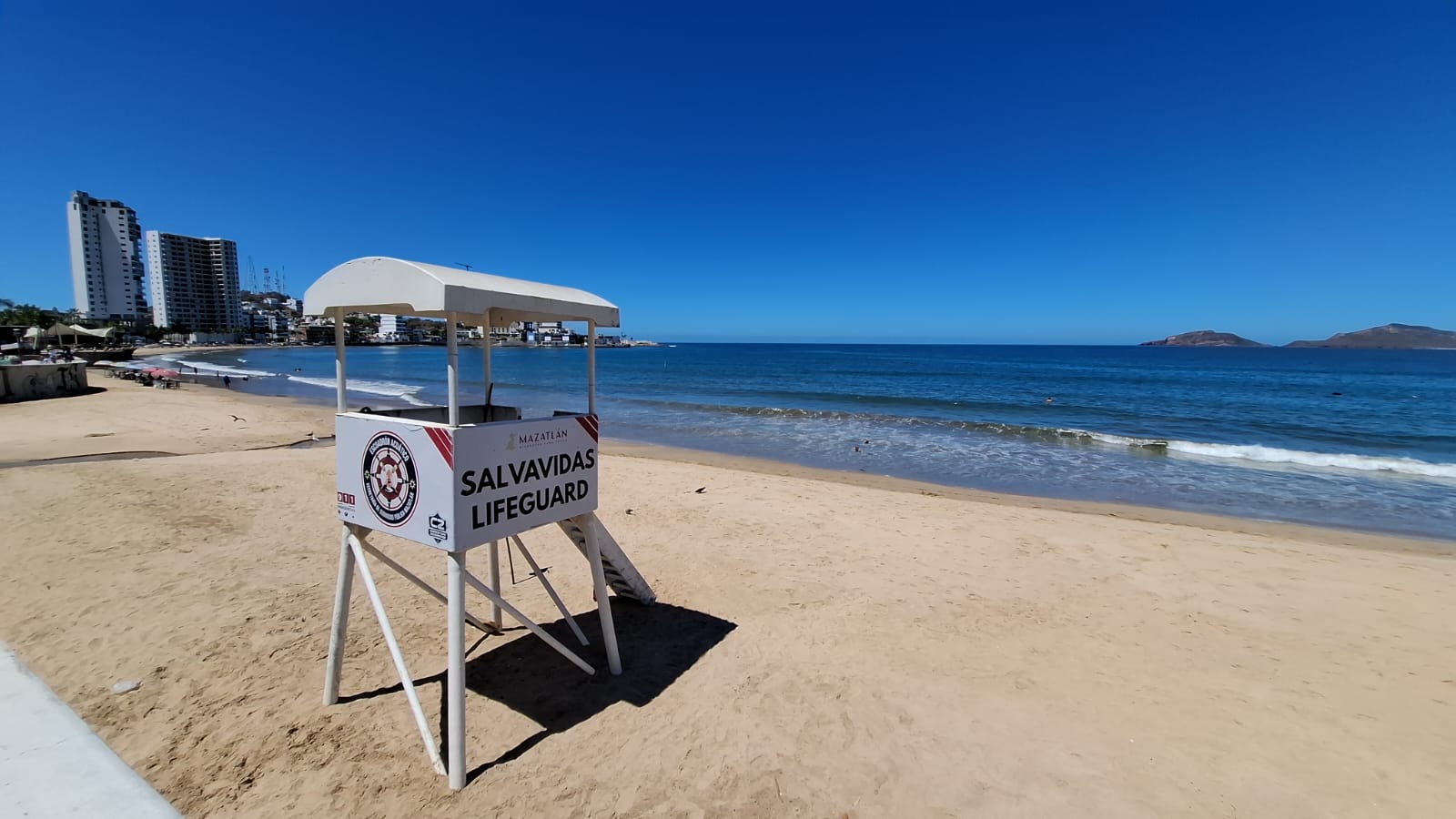 Silla de salvavidas juanto al agua en la playa en día soleado