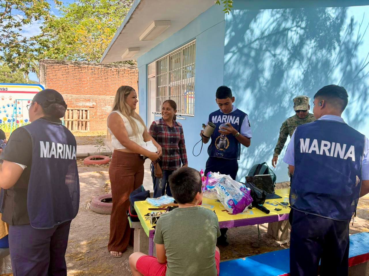 Tres personas de la marina junto a vecinos de la comunidad de El Habal en Mazatlán