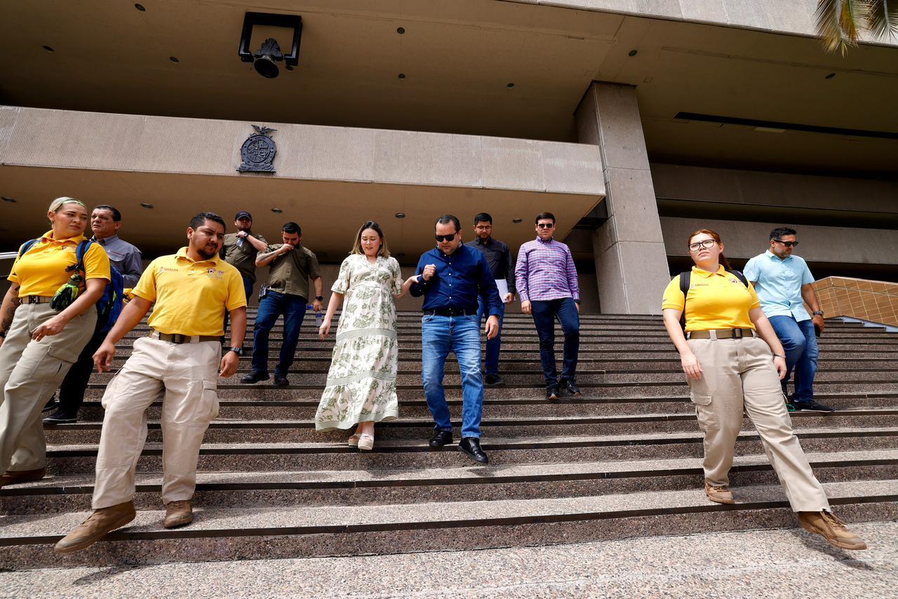 Autoridades de Sinaloa saliendo de palacio de gobierno acompañados de elementos de protección civil