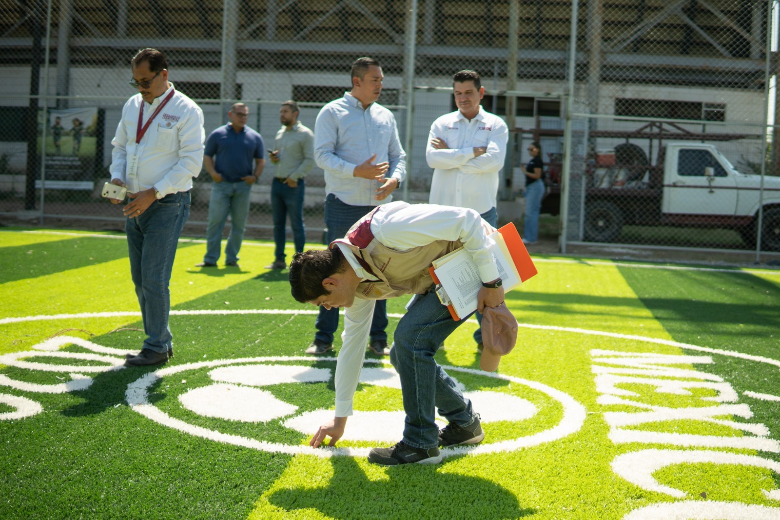 Funcionarios supervisando cancha de futbol