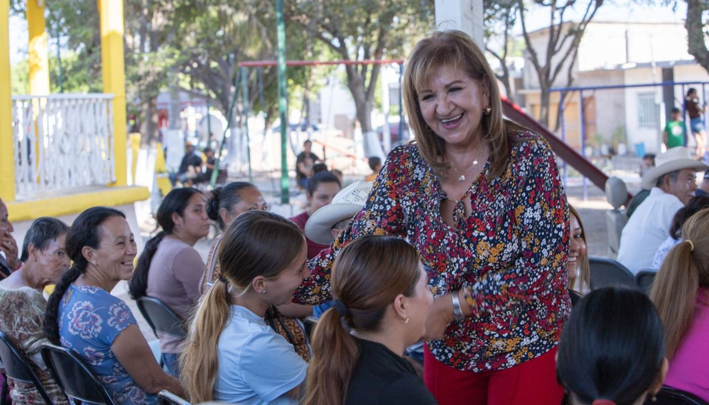 la diputada Tere Guerra entre personas en una junta bajo una techumbre