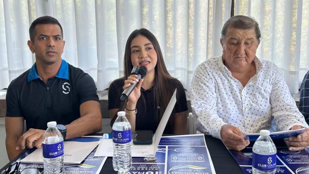 personas sentadas detrás de mesa con carteles