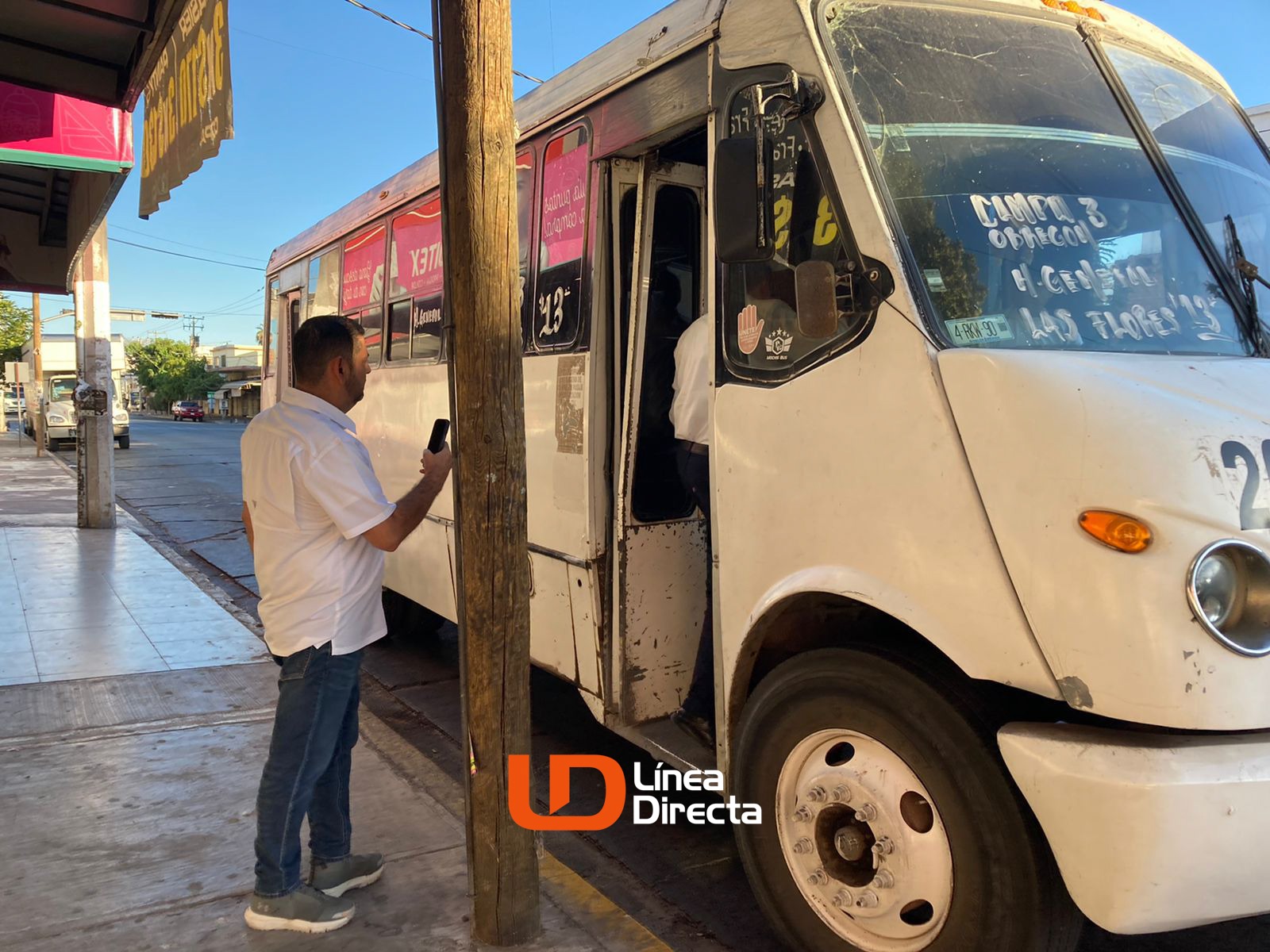 Persona en parada de autobús y autobús estacionado