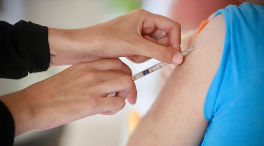 Enfermara aplicando vacuna en brazo