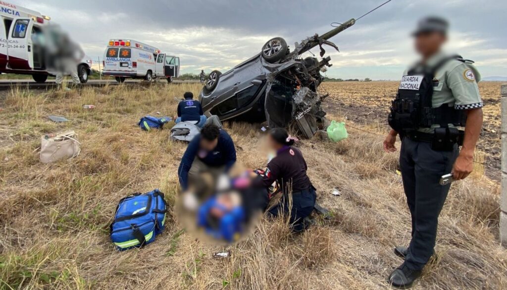 Paramédicos junto a personal de la Guardia Nacional con una camioneta volcada