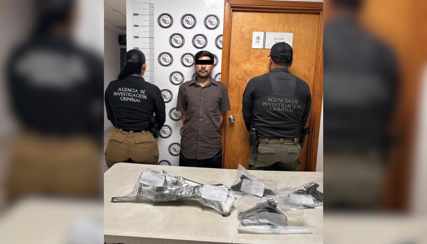 Dos agentes policiacos de espalda sy al medio un sujeto con el rostro cubierto y las manos a las espaldas