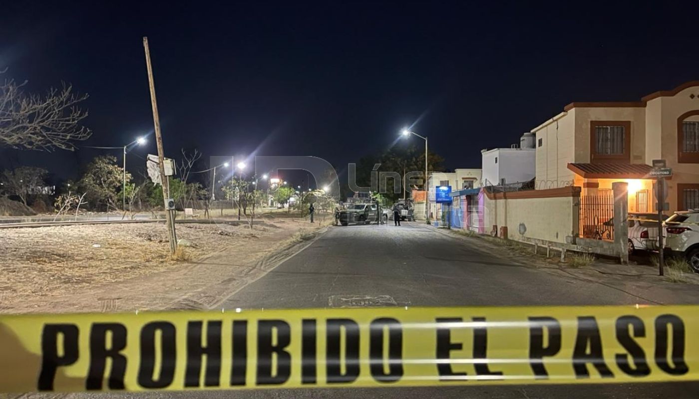 Cinta amarilla de precaución en una calle con casas