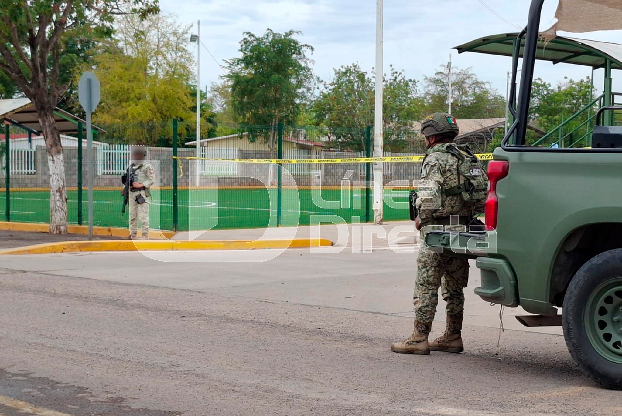 militares junto a una unidad de la corporación en una calle junto a una plazuela con una cinta de precaución