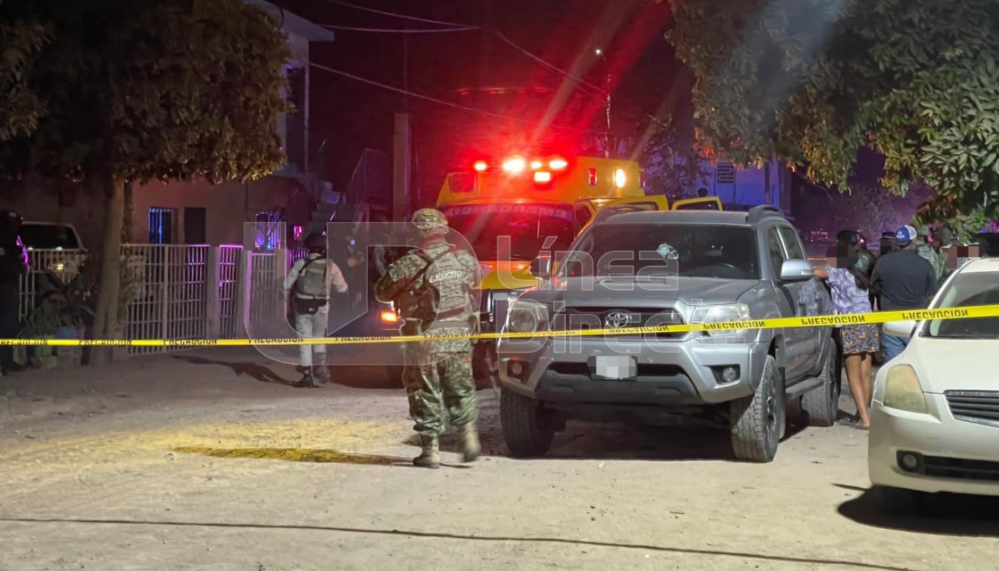 Agentes militares en un camino de terracería con una cinta amarilla de precaución y unidades de cuerpos de emergencia al fondo