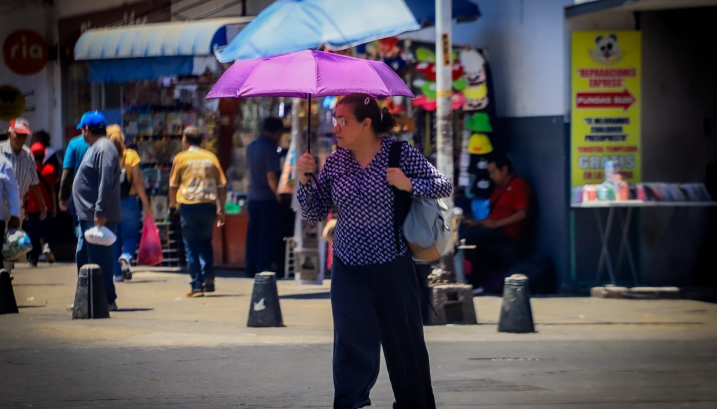 Mujer caminando con una sombrilla ante las altas temperaturas