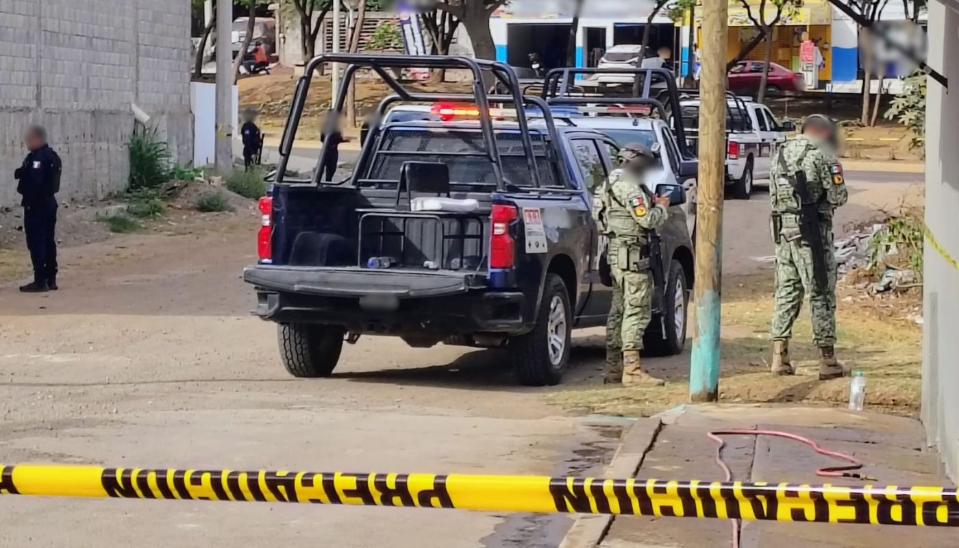 Patrullas y elementos policiacios desplegados en una calle con una cinta amarilla de precaución