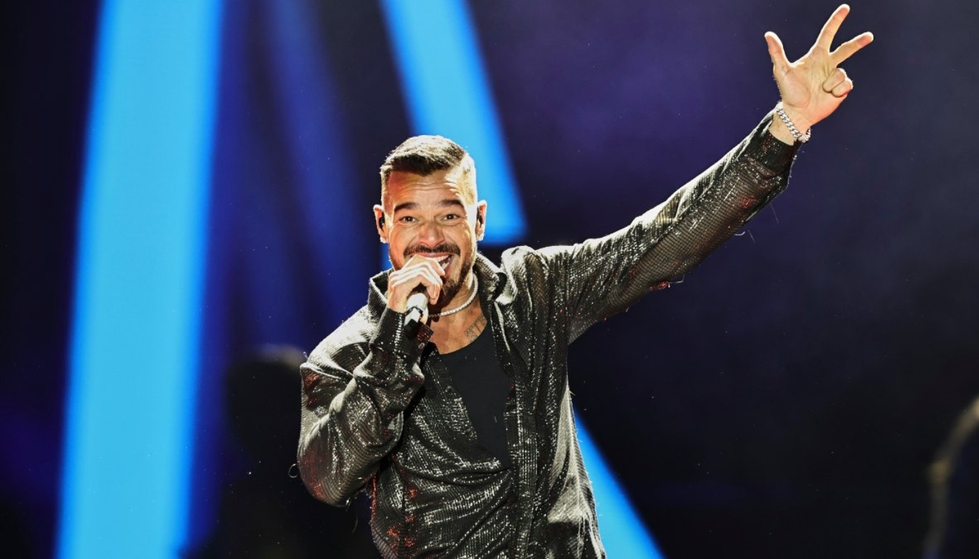 Ricky Martin con micrófono en la mano en concierto