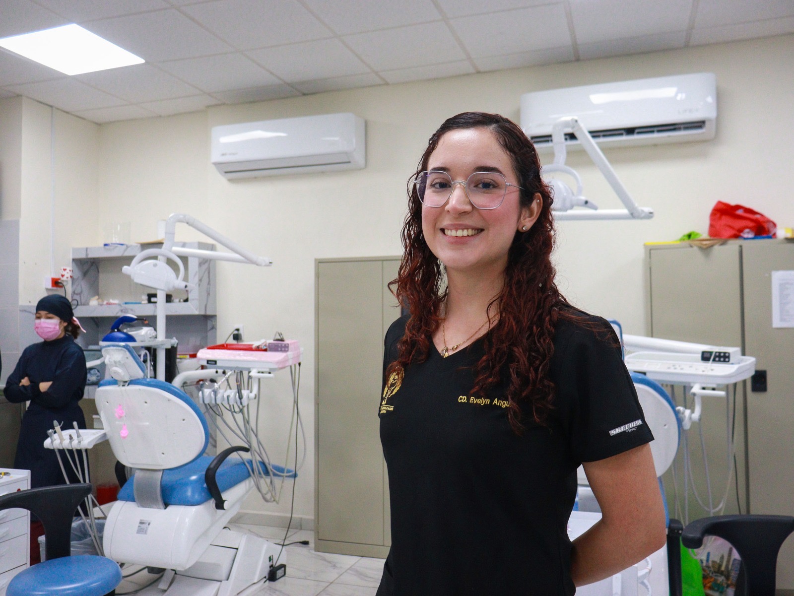 Consultorio de dentista junto a una mujer con pelo chino