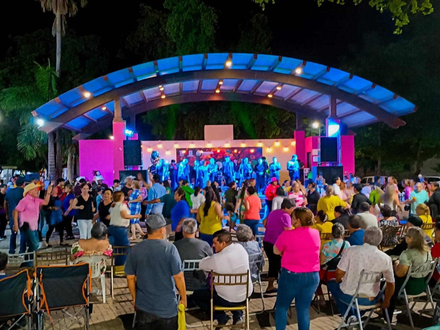 Personas bailando con banda en la plazuela