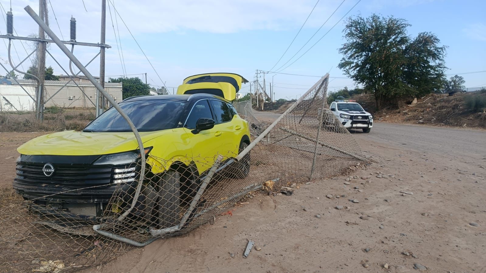 Vehículo Nissan Kicks impactado contra una cerca perimetral.