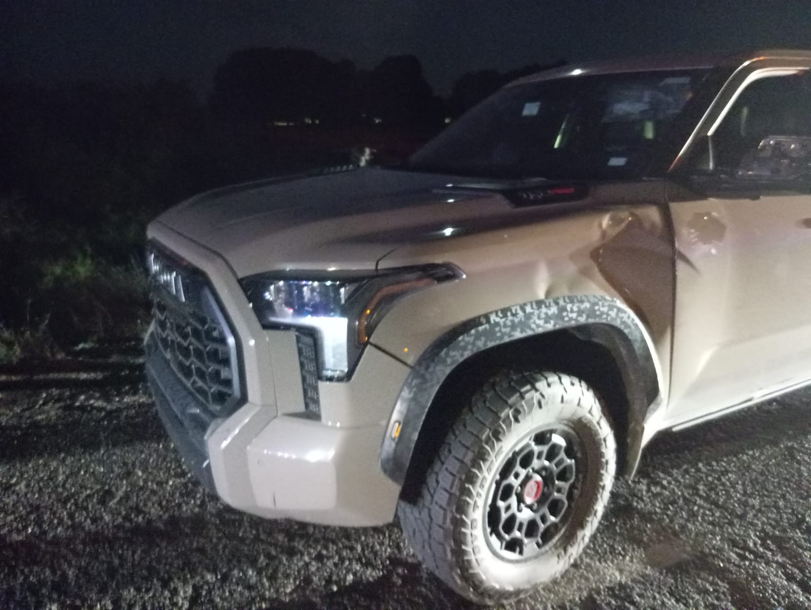 Toyota Tundra, de color arena, con daños en la carrocería.