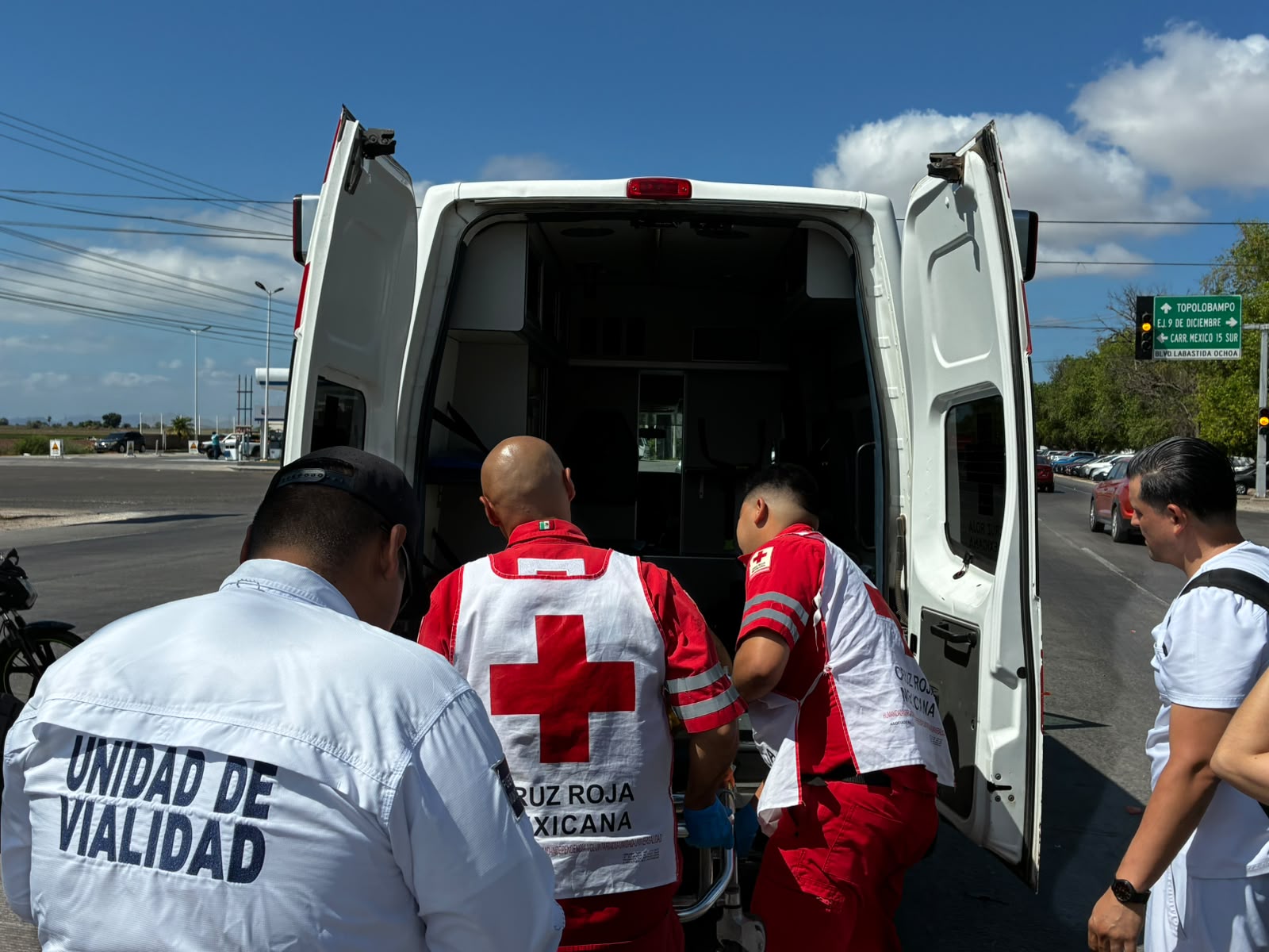 Paramédicos de Cruz Roja auxiliando al lesionado y un elemento de Vialidad resguardando la zona.