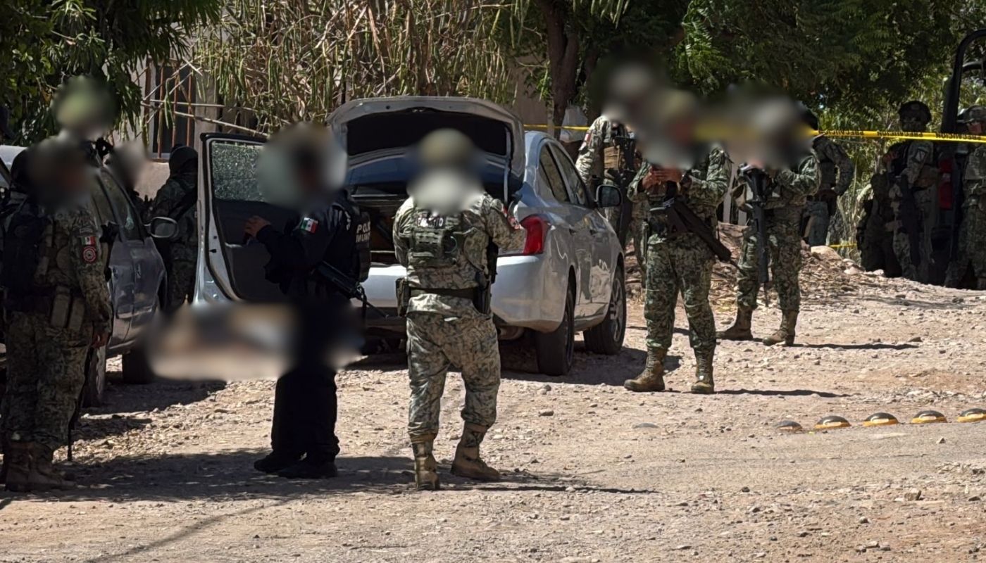 Elementos de la polic+ia y del ejército mexicano con un carro y cinta amarilla