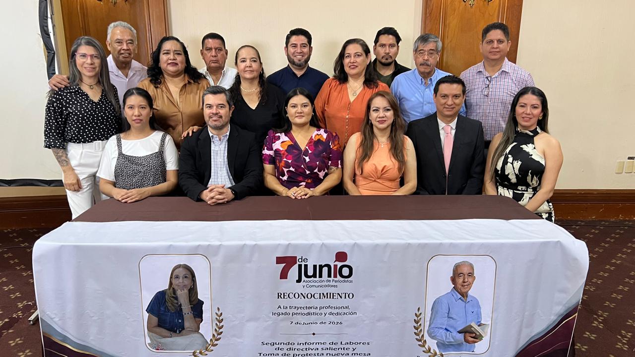 Personas sentadas y de pie detrás de mesa