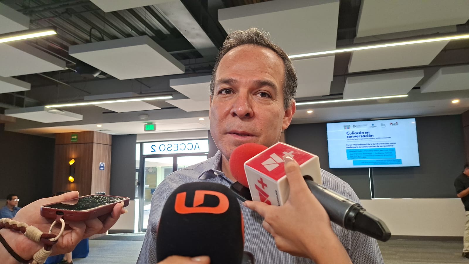 Persona con dos micrófonos de medos de comunicación