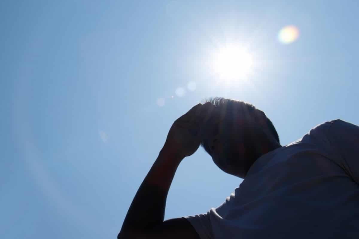 Persona con la mano en la cabeza y el sol arriba